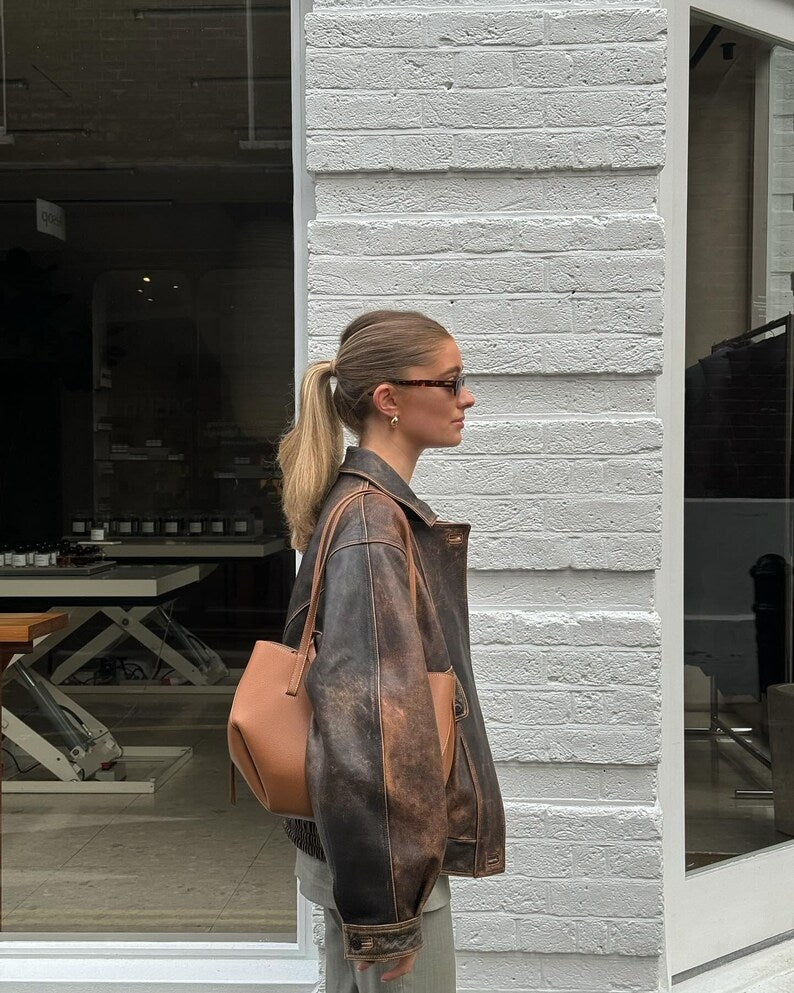 Distressed brown leather bomber jacket, zip front and ribbed cuffs, side view