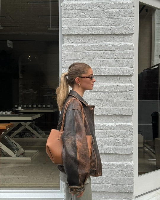 Distressed brown leather bomber jacket, zip front and ribbed cuffs, side view