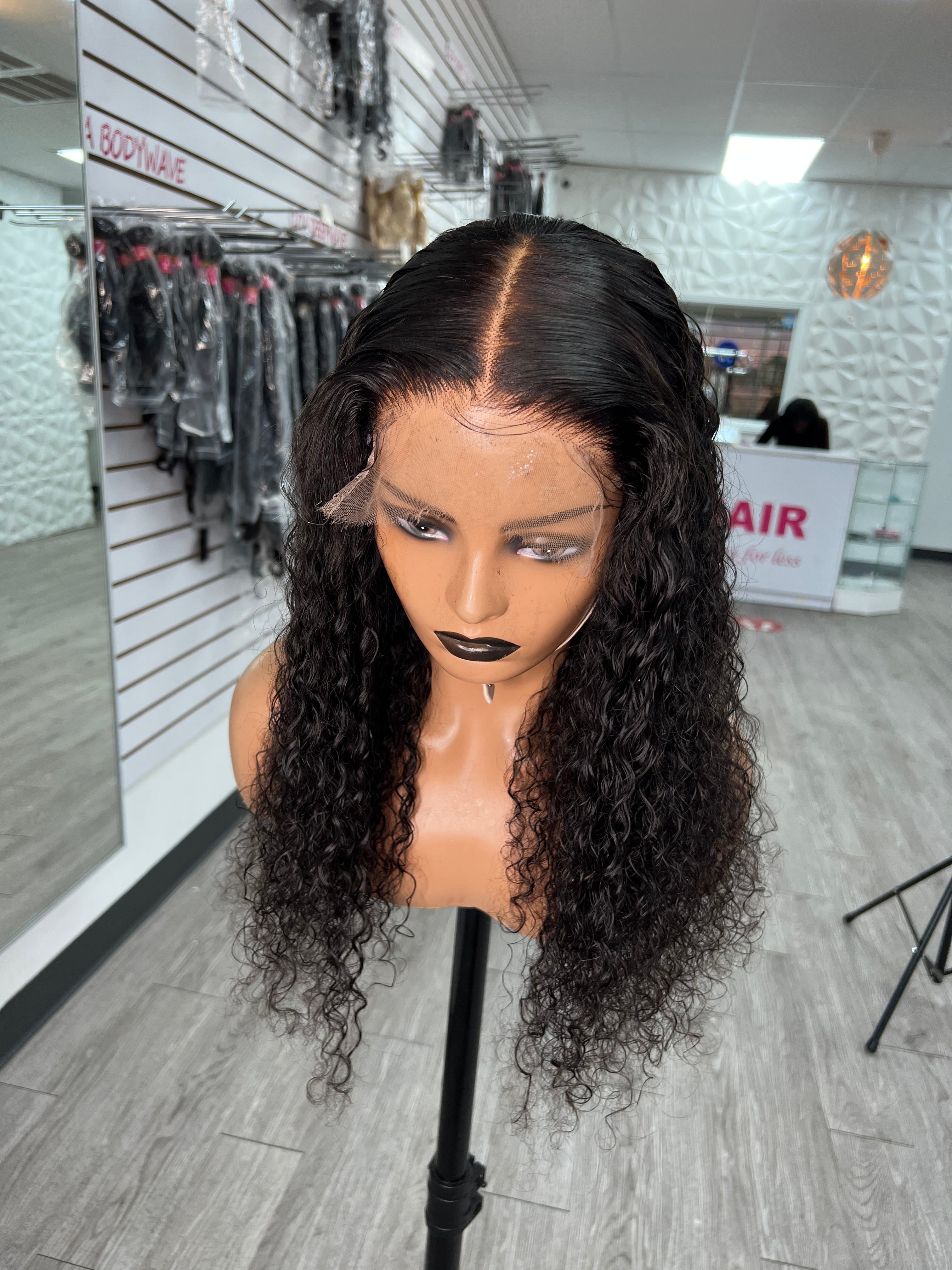Ariana Unit wig with deep black curly hair and center part, styled on mannequin.
