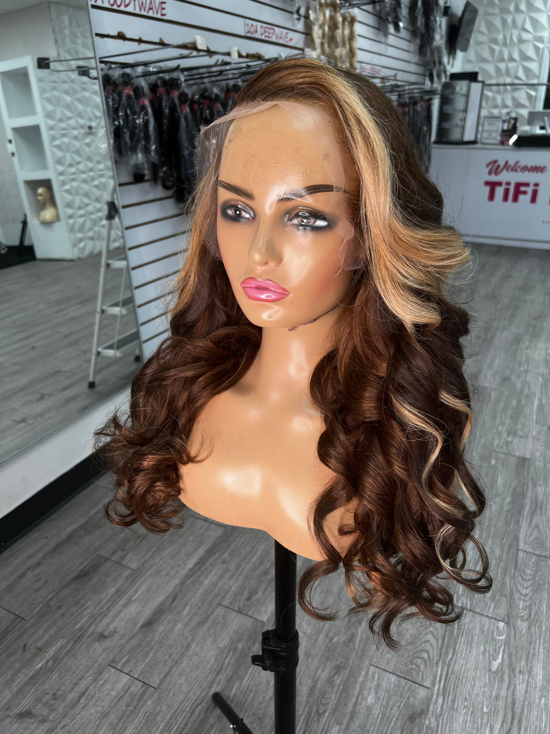 BRI WAVY UNIT wig on stand, voluminous dark-brown waves with light blonde at part