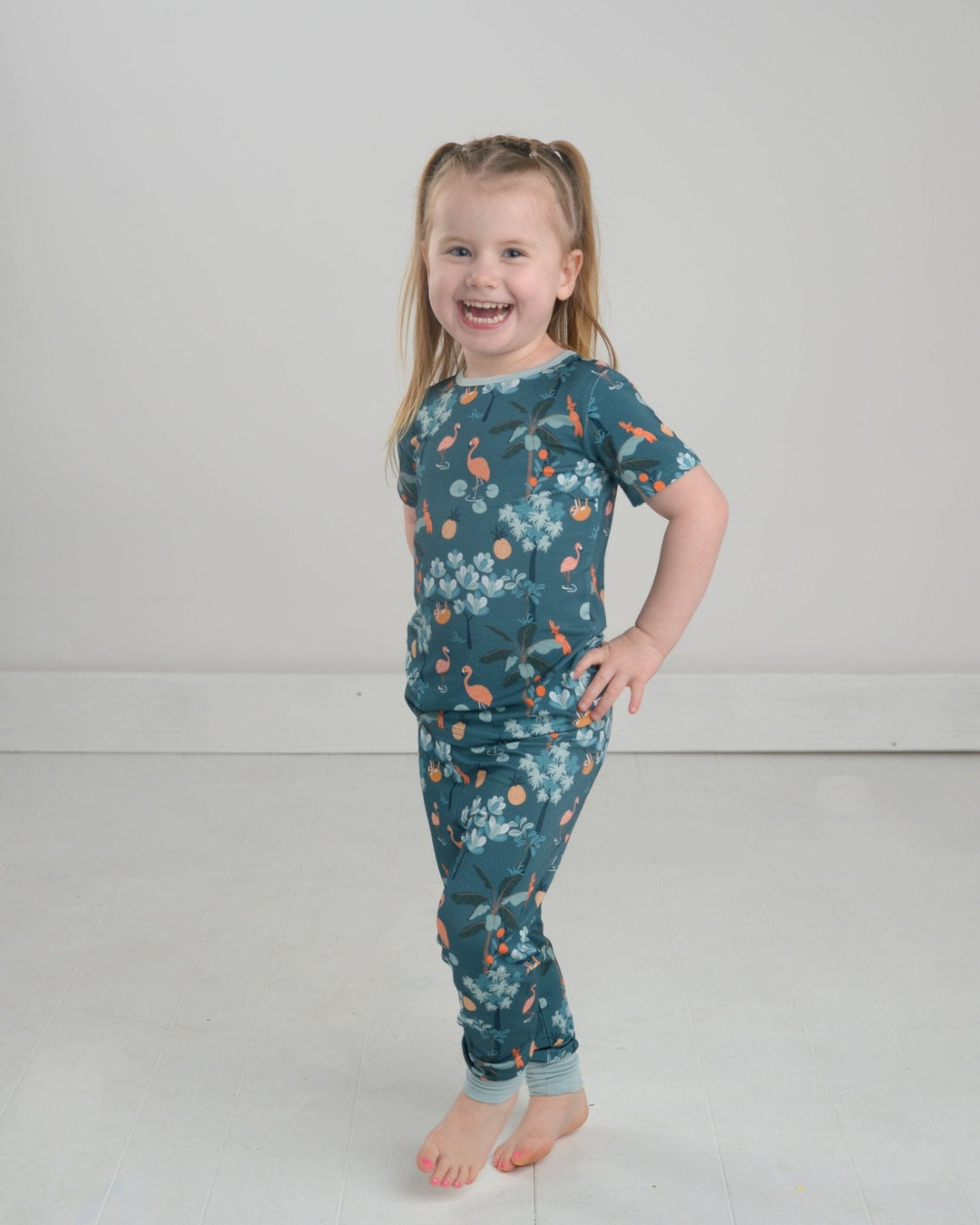 Jungle pajama set for kids: teal short-sleeve top and matching patterned leggings.