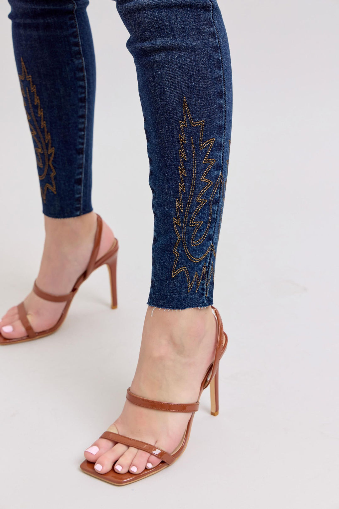 Nahaufnahme bestickter Saum dunkelblauer Skinny-Jeans am Fußbereich