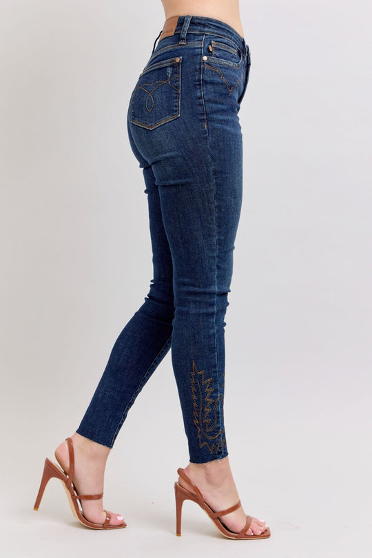 Rückansicht dunkelblaue Skinny-Jeans mit Stickerei am Saum und Gesäßtaschen