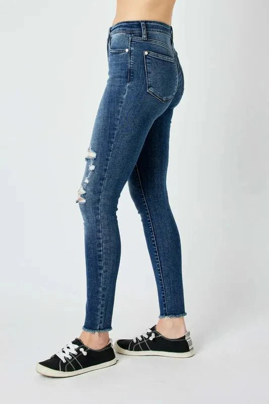 Dark high-waist skinny jeans, back view with small distressing on the leg