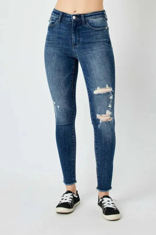 Dark high-waist skinny jeans with ripped knees and frayed hems