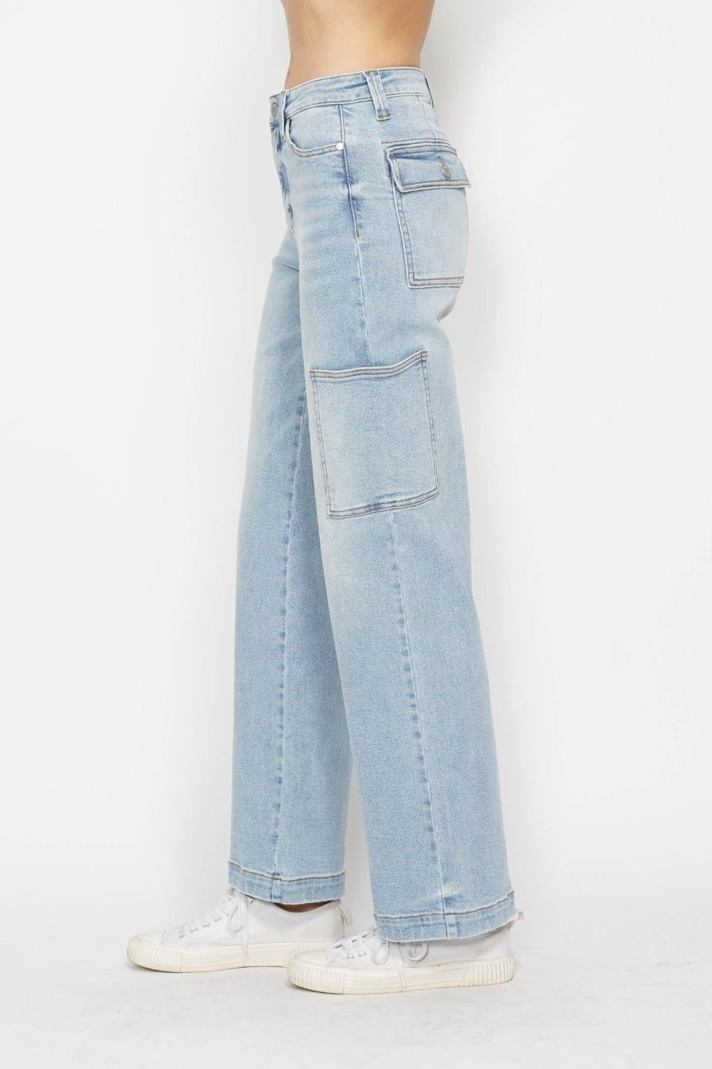 Light wash high-waist straight cargo jeans from back with large patch pockets and seam detailing