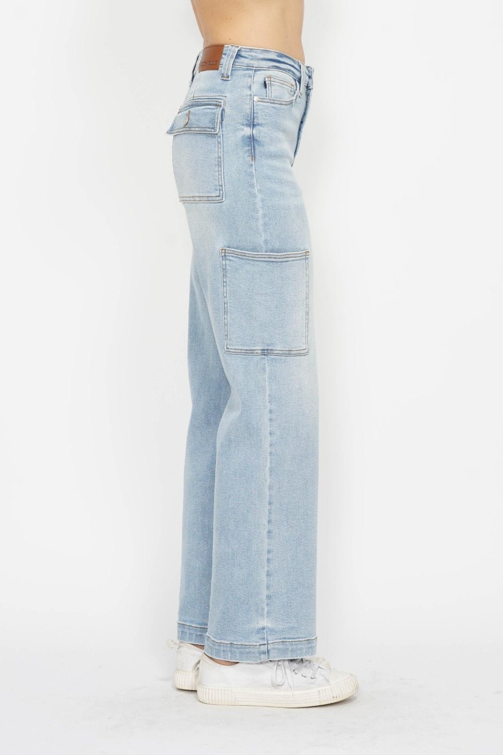 Side view of light wash high-waist straight cargo jeans with front patch pockets
