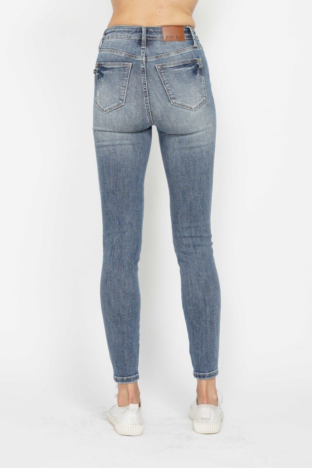 Back view medium wash skinny jeans with button fly and contrast whiskering