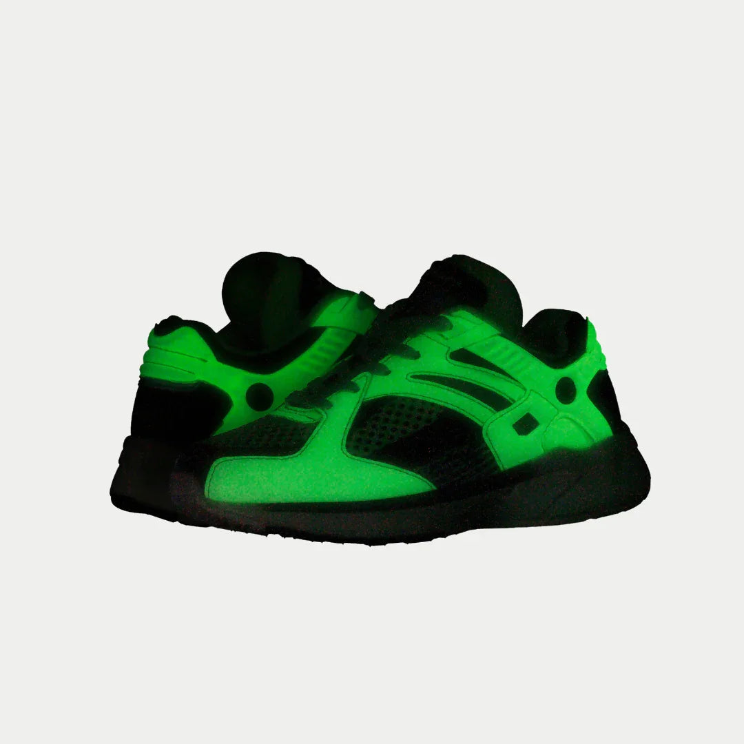 Light-up neon yellow kids sneakers with black details, glowing green from the soles