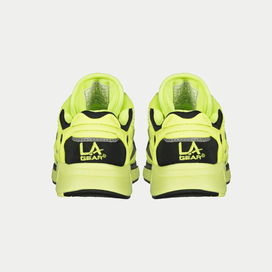 Outsole view: neon yellow kids sneakers with black traction tread and chunky rubber sole