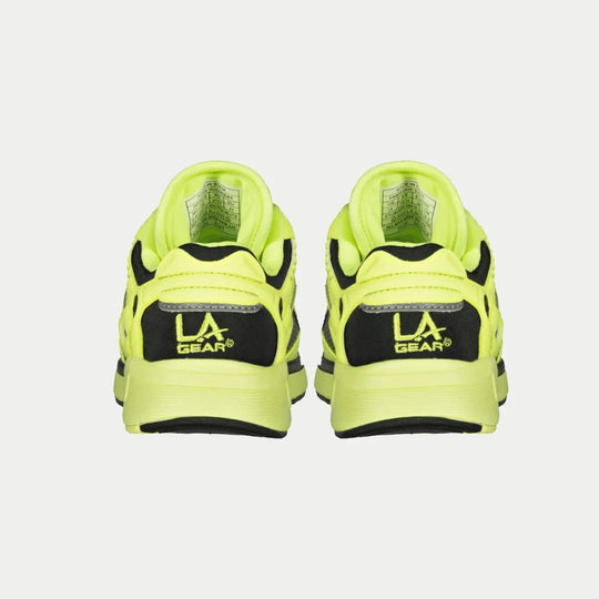 Outsole view: neon yellow kids sneakers with black traction tread and chunky rubber sole