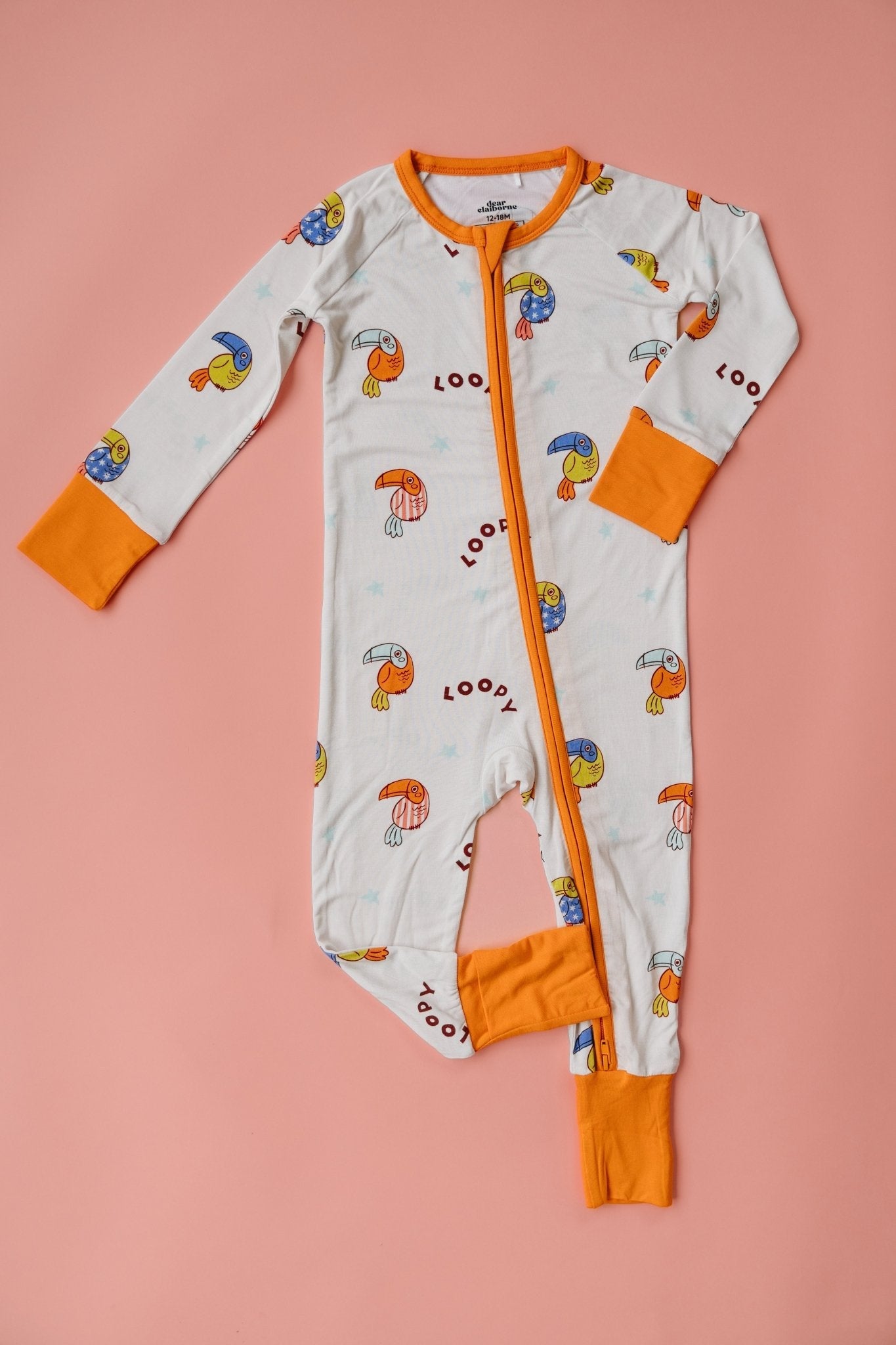 Dear Claiborne Loopy Zipper Romper in white with orange trim and colorful bird print, front zip