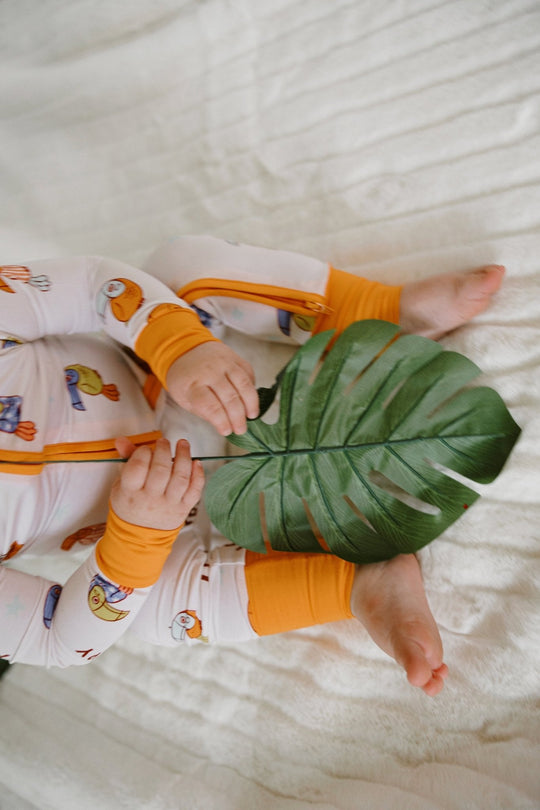 White zip romper with orange cuffs and loop bird print, full outfit view