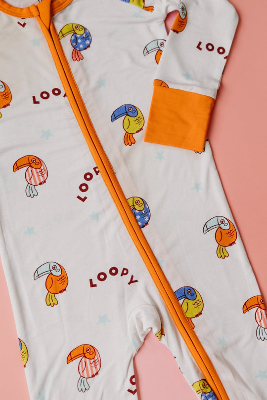 Zip area close-up: white romper with orange zipper trim and repeating birds and LOOPY text
