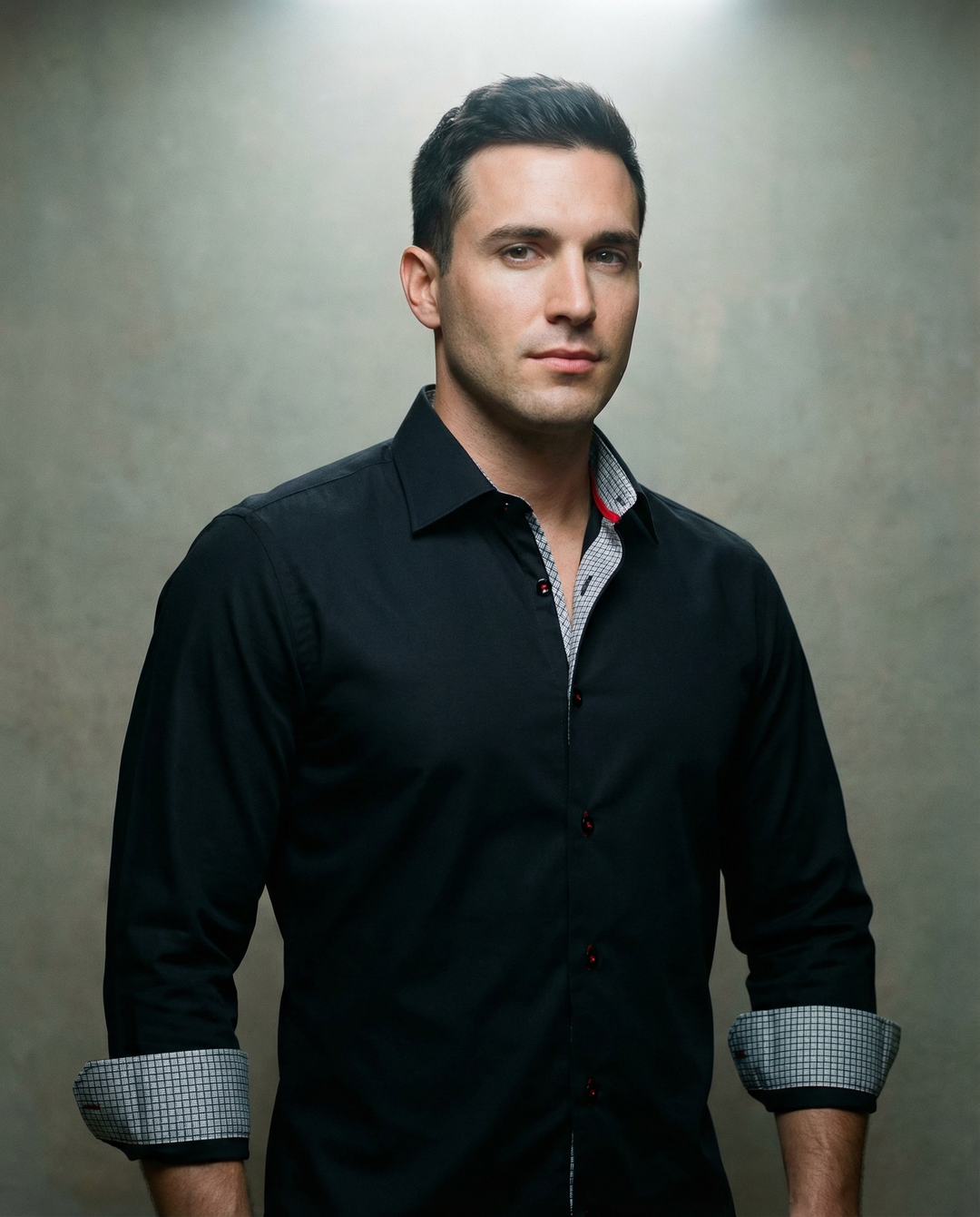 Black button-up shirt close view: contrast check inner collar, dark buttons.