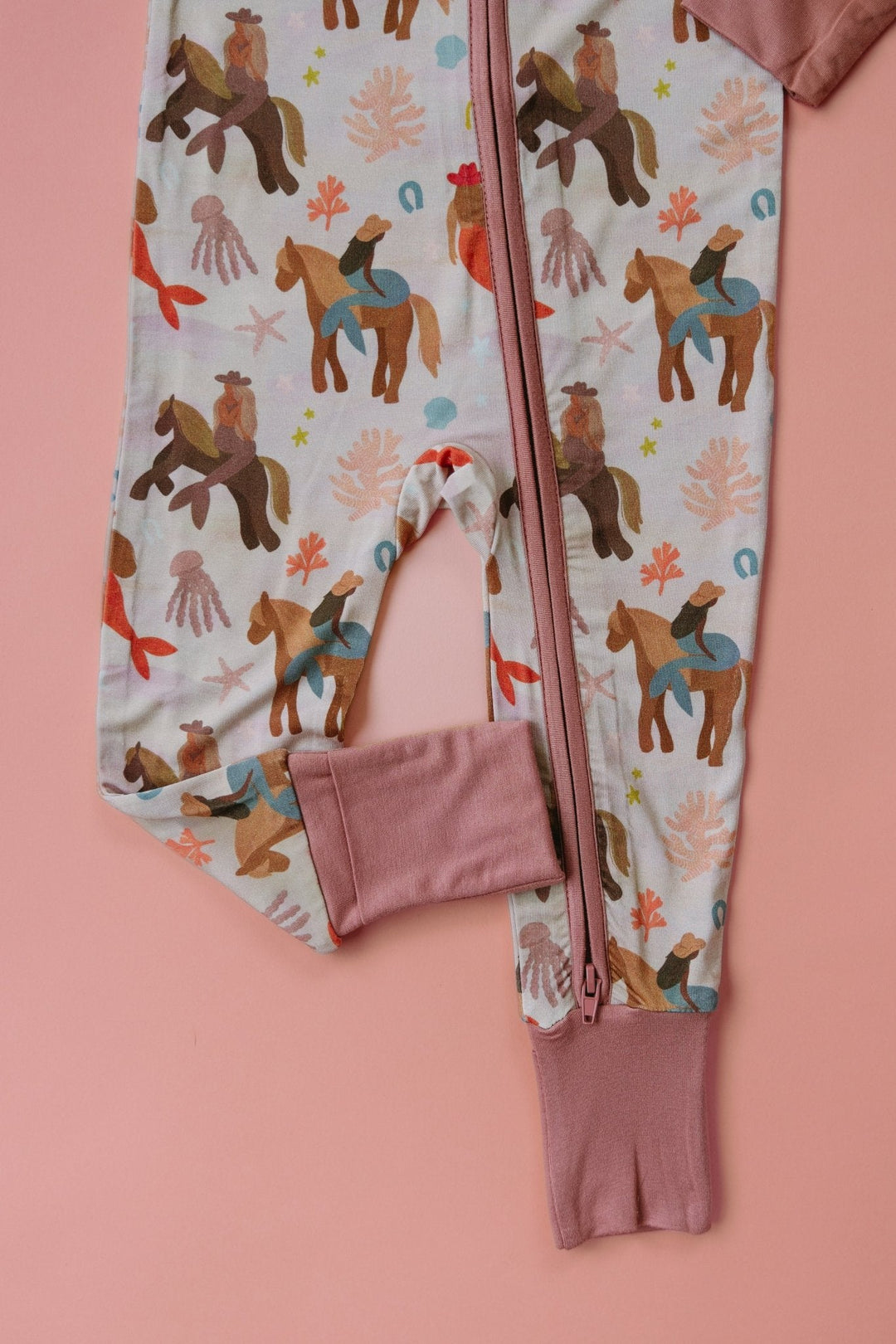 Close-up mermaid zipper romper: front zipper and attached pink pocket pouch