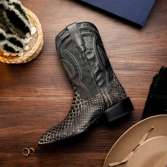 Black western boot on wood floor; pointed toe, stacked heel, and stitched shaft