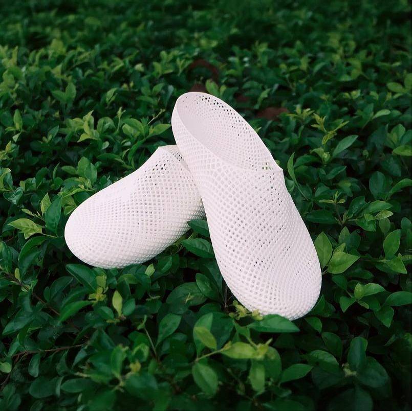 White 3D printed slippers with openwork grid texture, slip-on clog style.