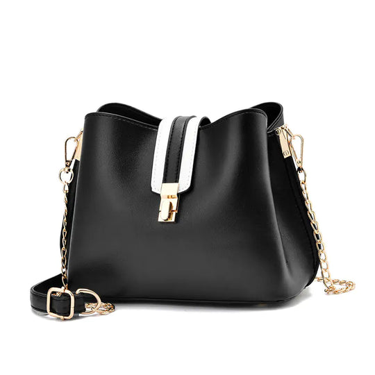 Black bucket bag with white strap detail, gold hardware, and chain crossbody strap