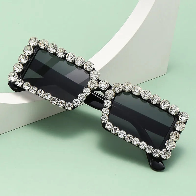 Square rhinestone sunglasses, bright black frame with dark lenses and jeweled edges