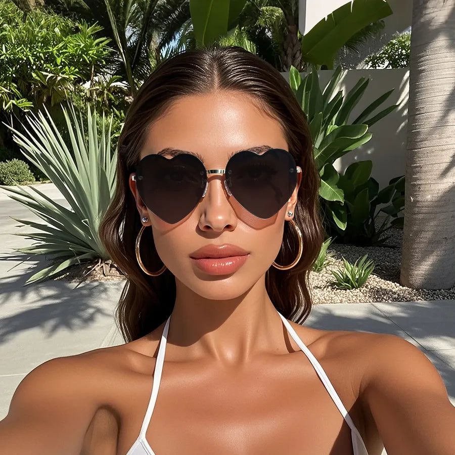 Heart-shaped half-rim sunglasses with black frames and dark lenses