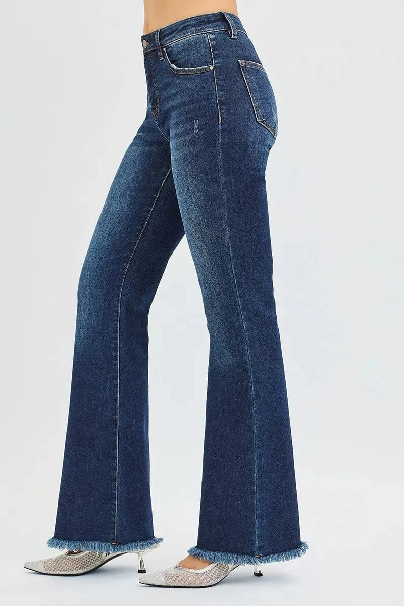 Side view dark wash flare jeans with back yoke seams and frayed hem