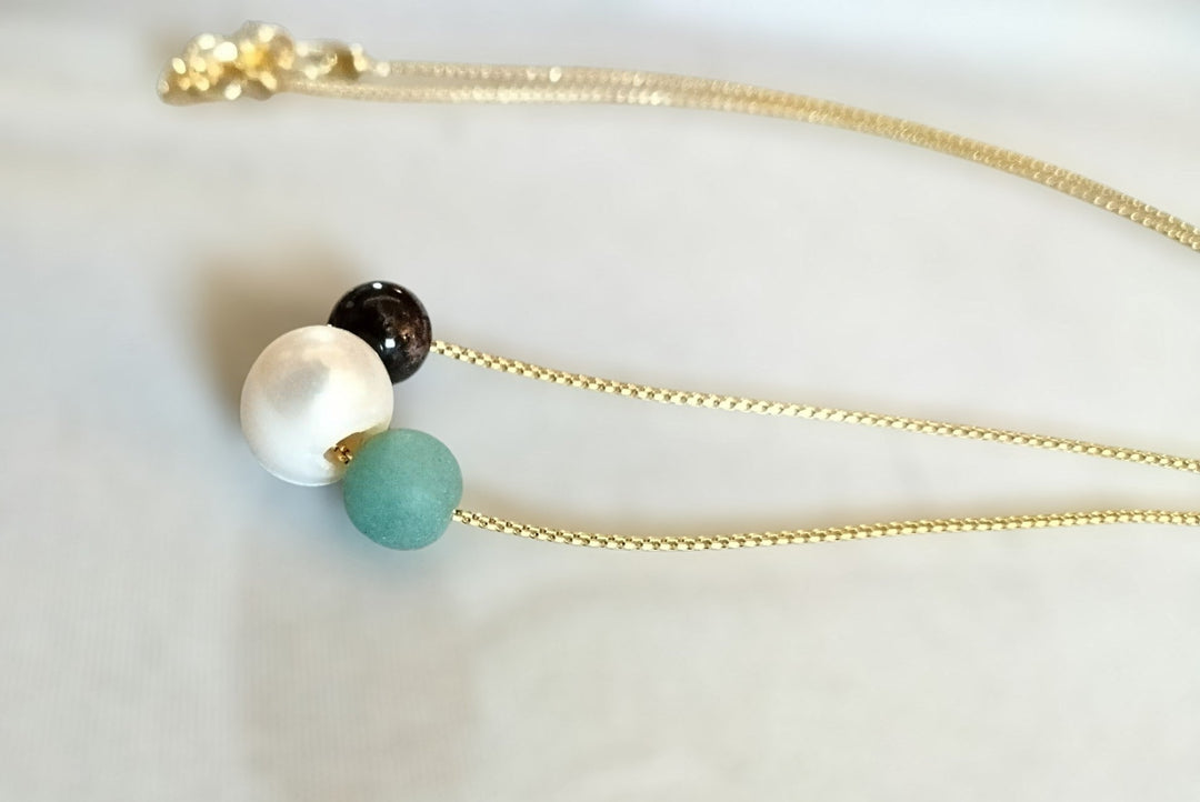Minimalist gold chain necklace with white pearl, dark bead, and turquoise bead