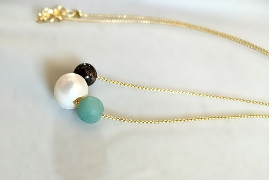 Minimalist gold chain necklace with white pearl, dark bead, and turquoise bead