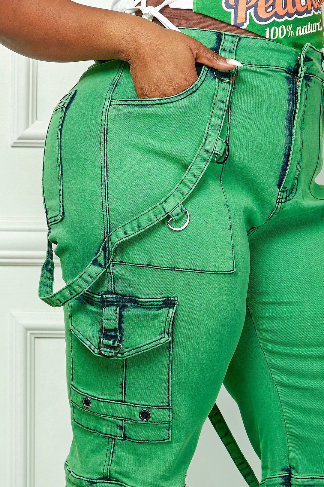 Green denim cargo pants close-up: stitched front pocket with metal ring detail
