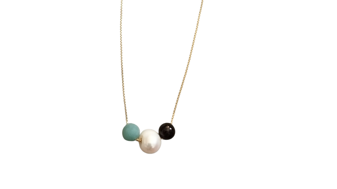 Gold chain necklace with three beads: turquoise, white pearl, and dark bead
