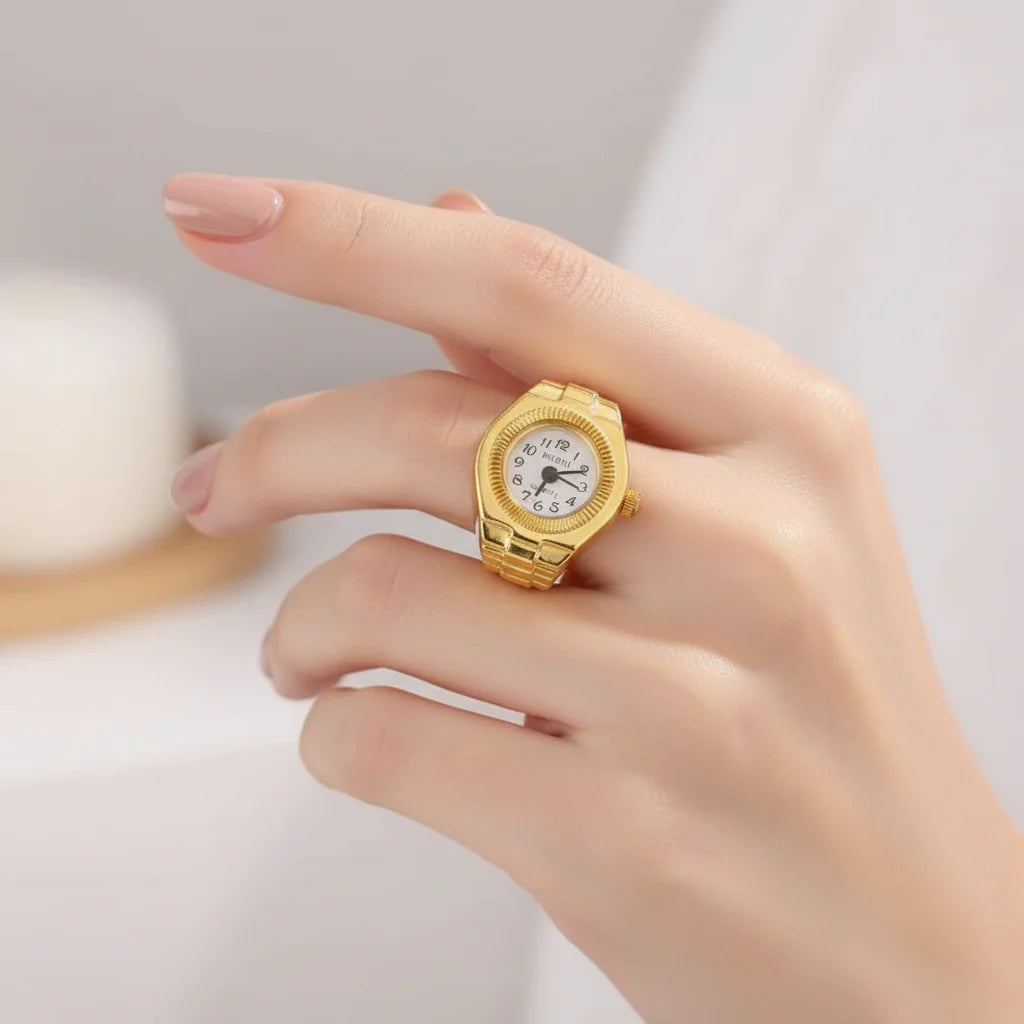 Goldtone quartz watch ring with white face on finger