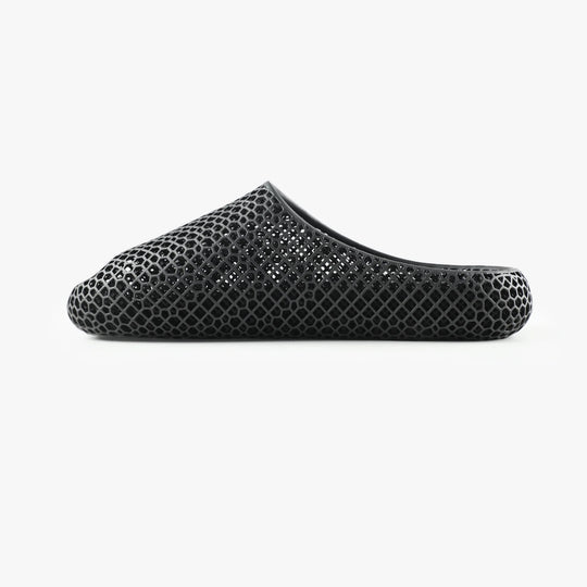 Black 3D-printed slipper, side view with open toe and honeycomb hex pattern upper