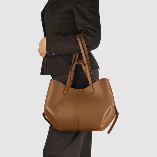 TAKEASY calf leather tote bag in chocolate brown, carried on shoulder with long straps.