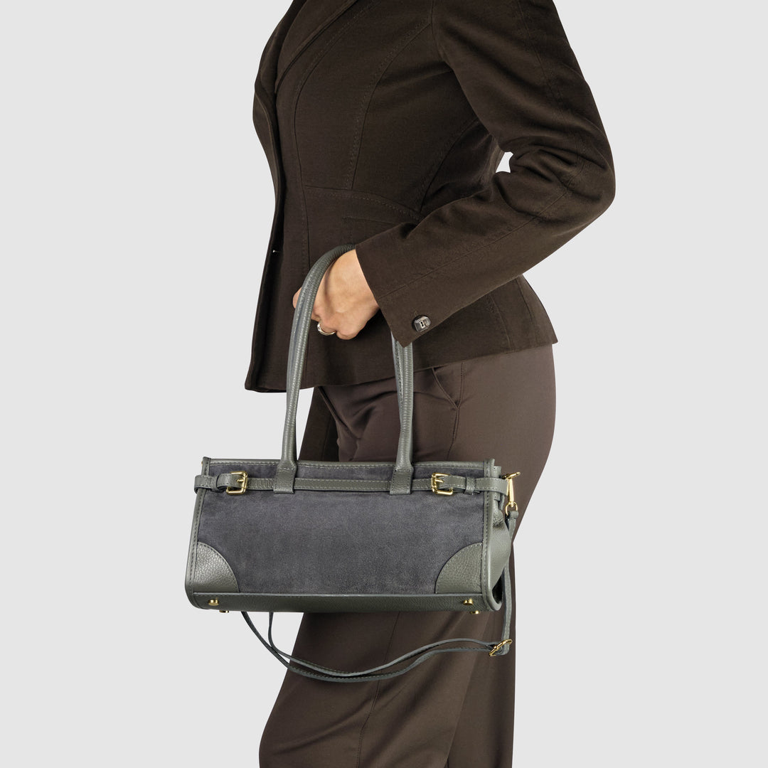Dark grey shoulder bag worn on person; gold-tone buckles and crossbody strap hardware