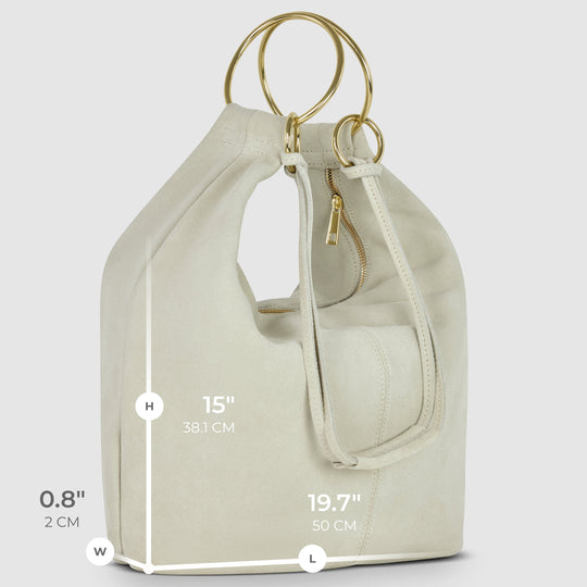 Cream suede hobo bag side view with zip pocket, ring handles, and inner strap