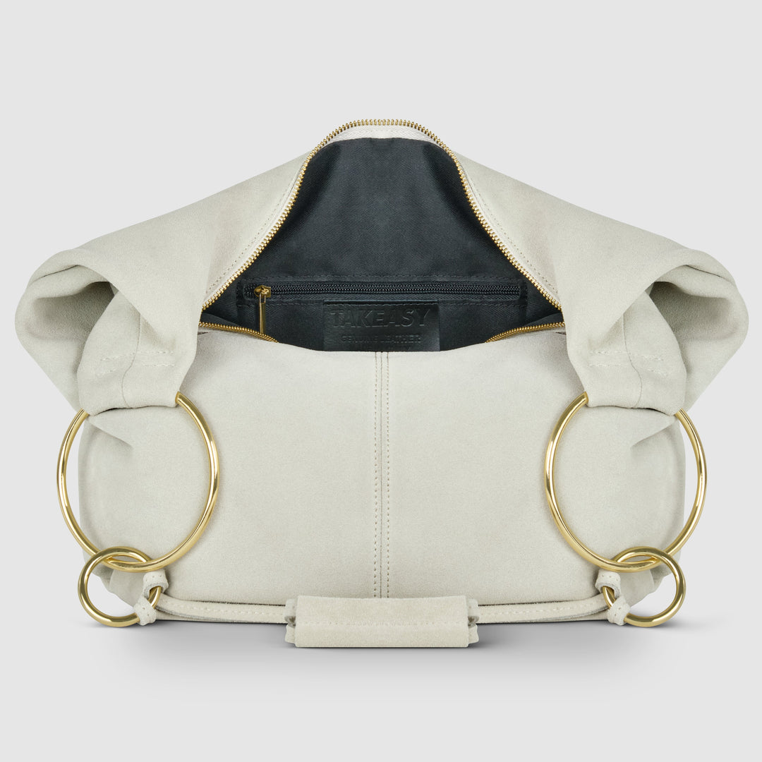Cream suede hobo bag with zip-top opening and ring handles, front interior view