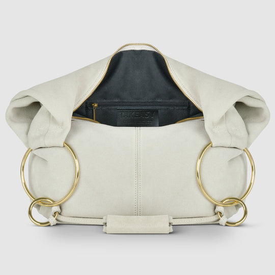 Cream suede hobo bag with zip-top opening and ring handles, front interior view