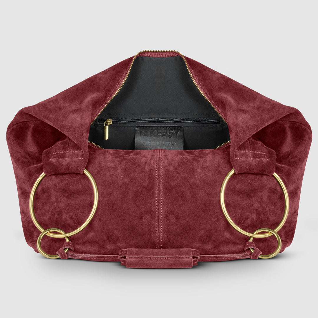 Burgundy suede hobo bag with zip-top opening and interior brand label
