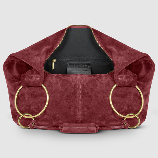 Burgundy suede hobo bag with zip-top opening and interior brand label