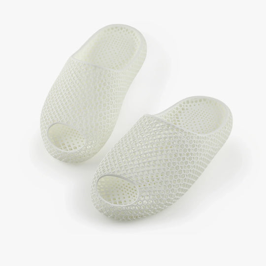 White 3D-printed slippers, angled pair with open toe and raised honeycomb texture