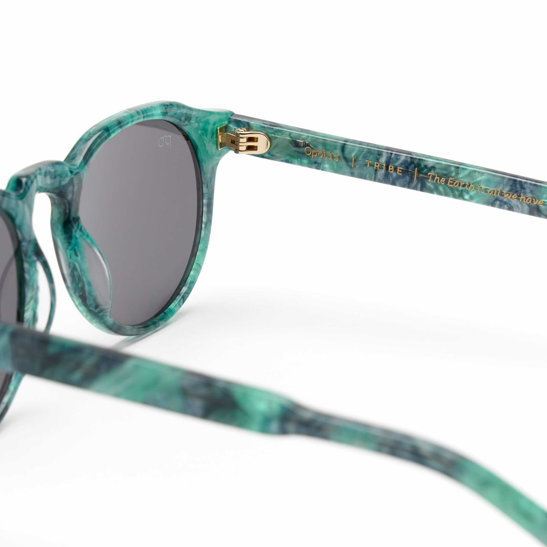 Tribe sunglasses side view with teal marbled frame and dark lenses