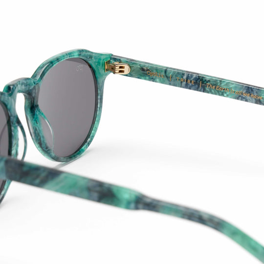Tribe sunglasses side view with teal marbled frame and dark lenses