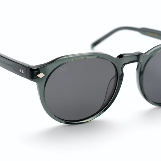 Tribe sunglasses close-up: dark gray frame, dark lenses, small diamond detail