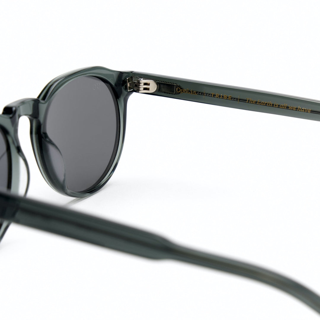 Tribe sunglasses temple close-up on dark gray frame with engraved branding