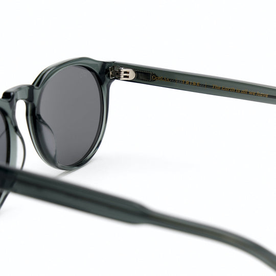 Tribe sunglasses temple close-up on dark gray frame with engraved branding