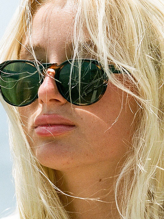 Teal marbled Tribe sunglasses worn, dark oval lenses