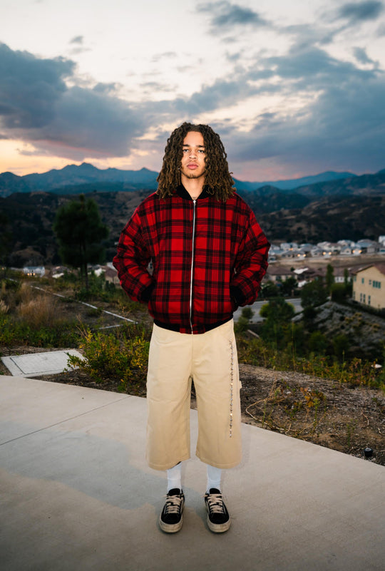 Reversible bomber worn: red plaid side with black zipper, ribbed cuffs, and hem