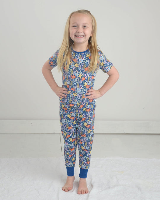 Wildflower pajama set, front view: short-sleeve shirt and tapered floral pants on blue